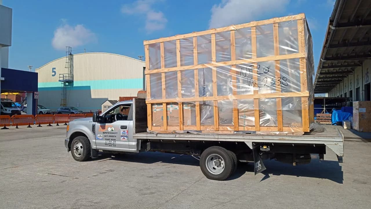 Unidad tipo estacas transportando una estructura embalada