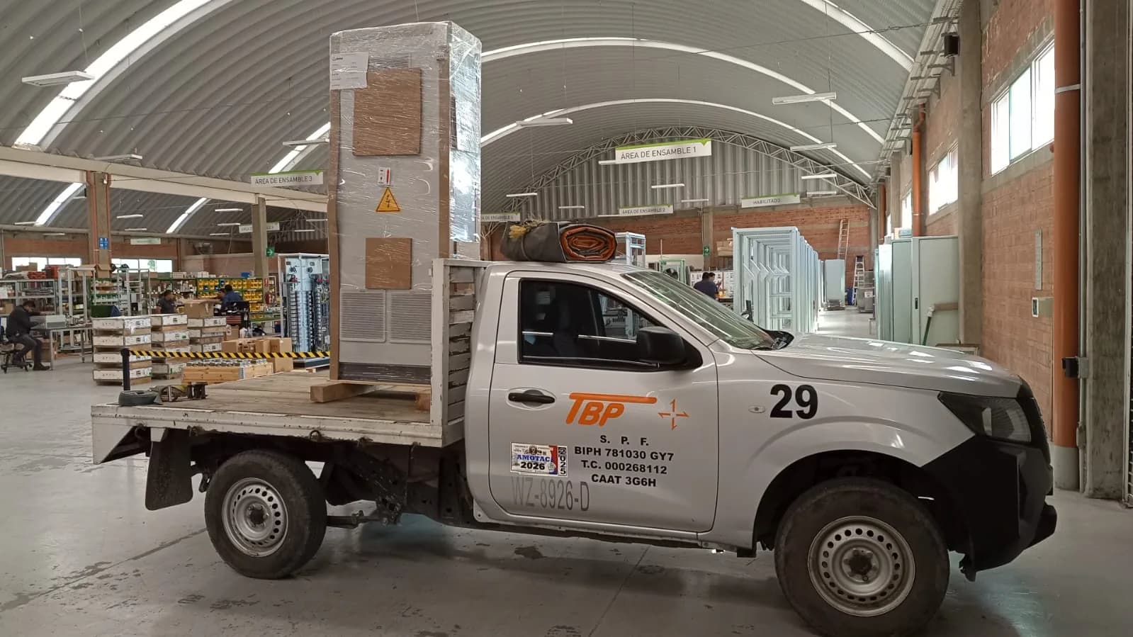 Unidad tipo estacas con equipo industrial dentro de un almacén